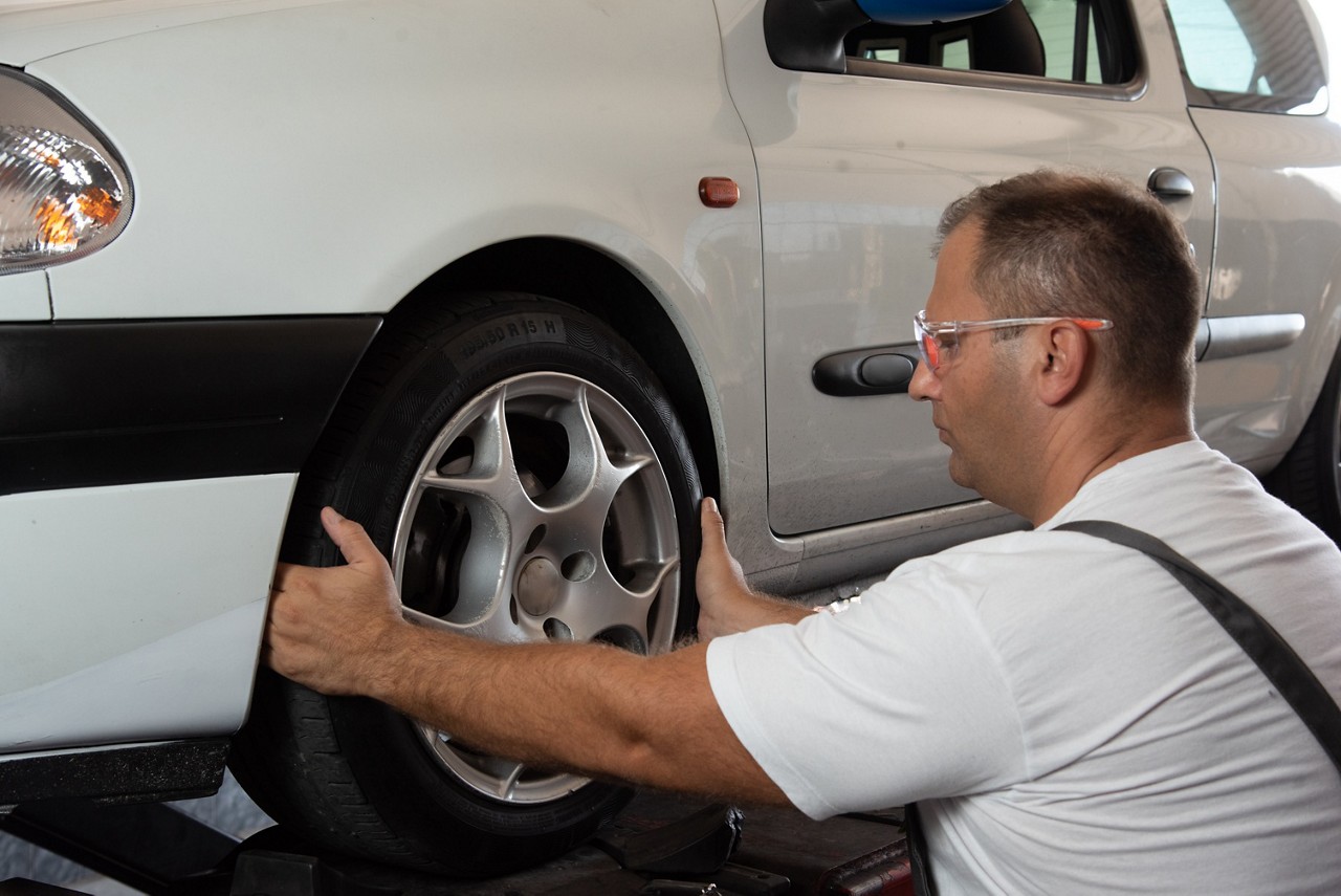Mechaniker, der die Achsvermessung durchführt