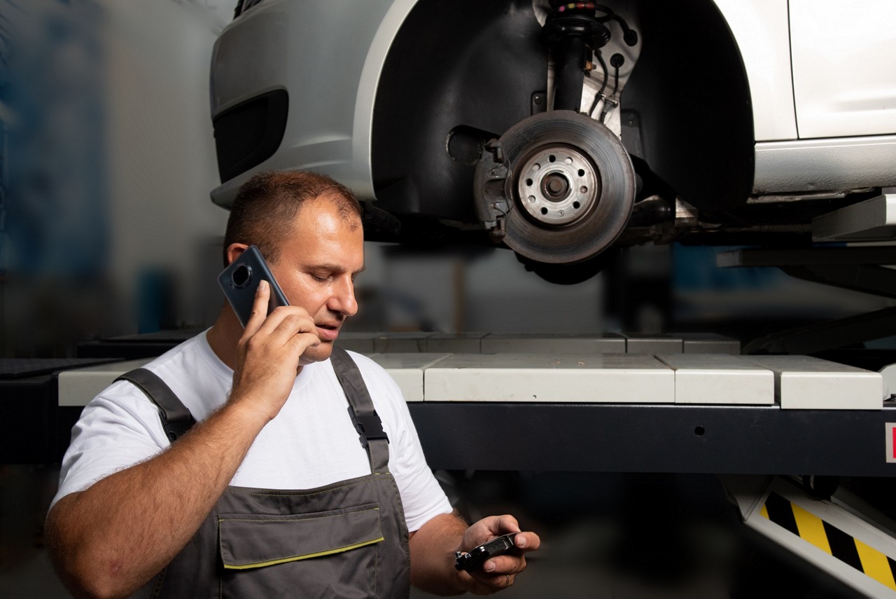 Mecánico de Garage Gurus atendiendo una llamada técnica en un taller