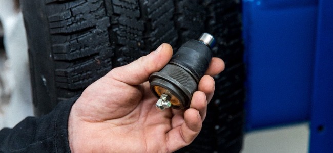 mechanic-holding-ball-ioint Mechanic holding ball joint in his hand.