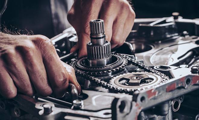 engine-and-transmission-being-repired Mechanic working on engine transmission