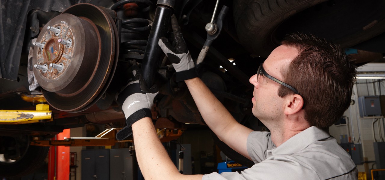 how-shocks-struts-wear-out-hero Auto technician inspecting shocks.