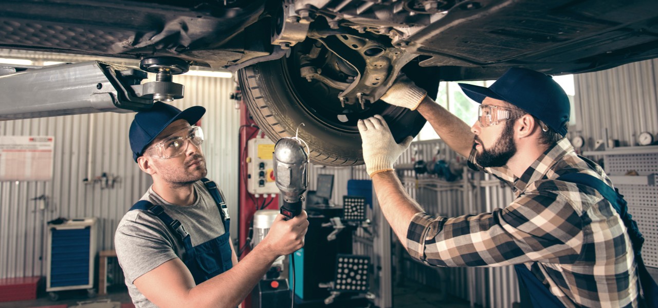 technicians-examining-vehicle-hero Technicians examining underbody of vehicle