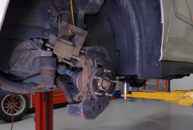 how-to-do-complete-brake-job-step-3 Vehicle on lift with tire off
