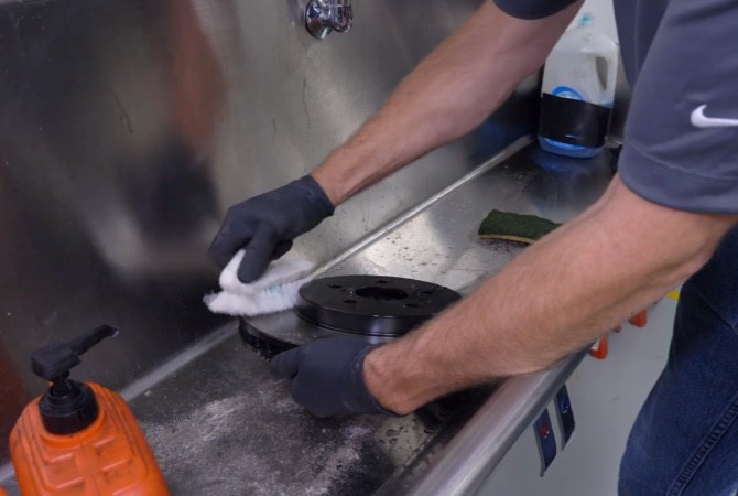 how-to-do-complete-brake-job-step-4 Technician washing brake rotor