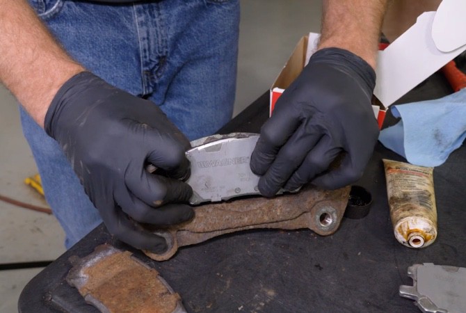 how-to-do-complete-brake-job-step-8 Technician installing new brake pads